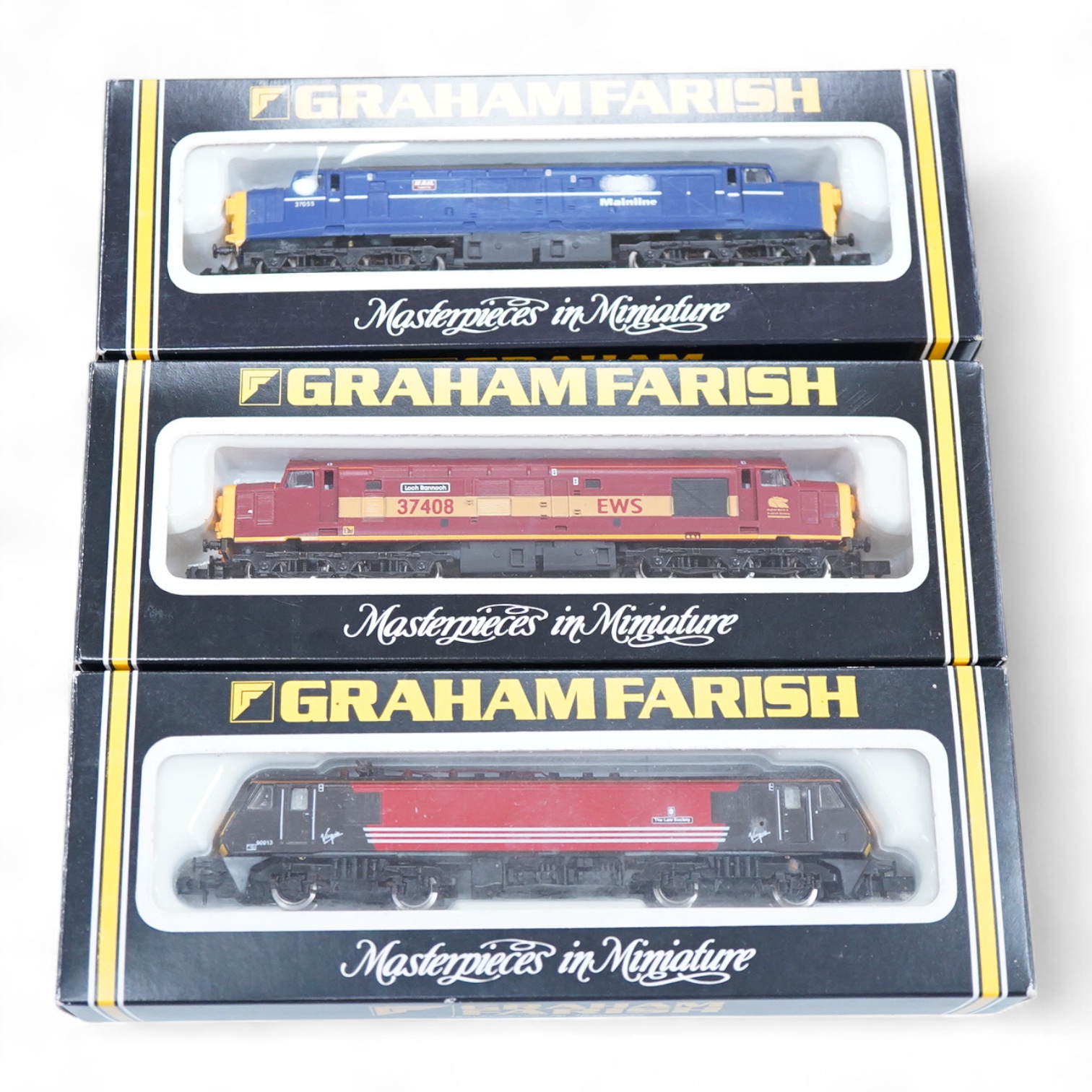Three boxed Graham Farish N gauge railway electric and diesel locomotives; a Virgin class 90, the Law Society 90013 (882A), a Mainline class 37, 37055 (803D) and an EWS class 37, 37408 (803E).